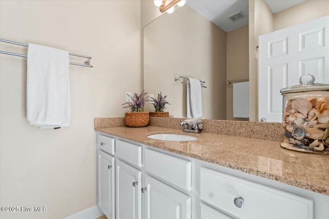 bathroom with vanity, visible vents, and baseboards