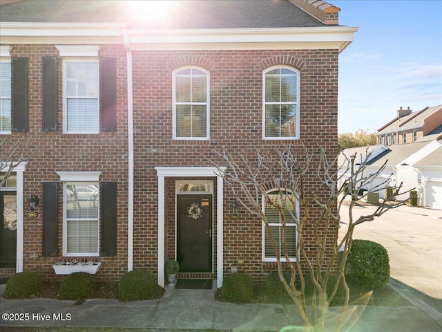 multi unit property with a garage, concrete driveway, and brick siding