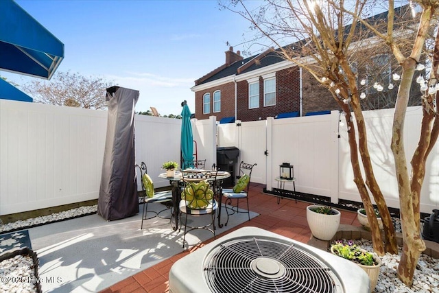 view of patio / terrace featuring central AC, outdoor dining area, and a fenced backyard