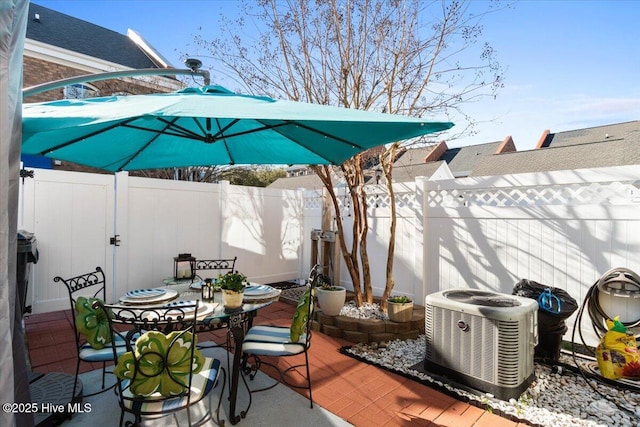 view of patio / terrace featuring central AC, outdoor dining space, and a fenced backyard