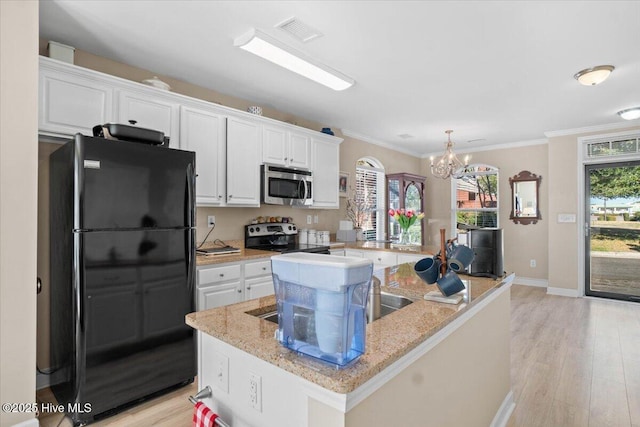 kitchen featuring visible vents, white cabinetry, appliances with stainless steel finishes, light wood finished floors, and an island with sink