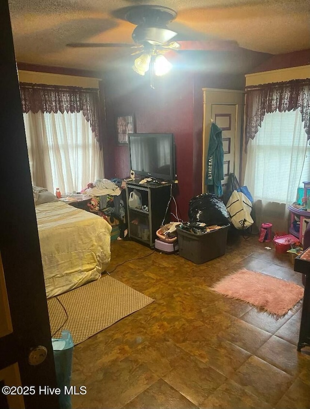 bedroom with a ceiling fan and a textured ceiling