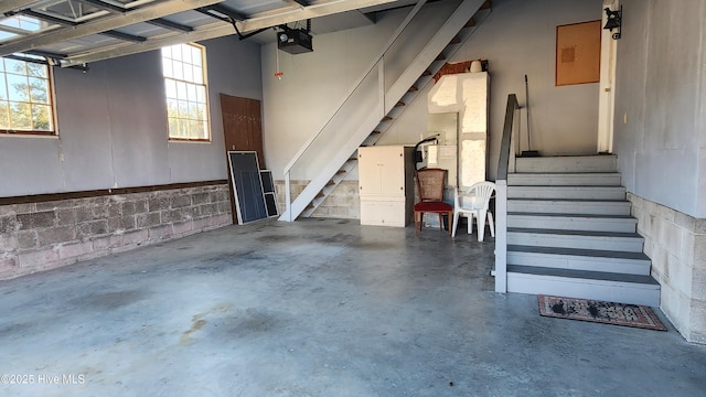 garage featuring concrete block wall and a garage door opener