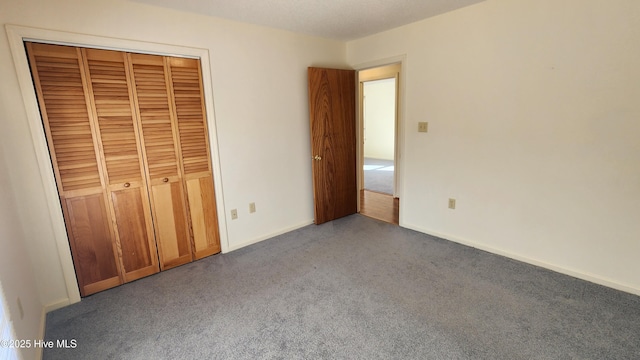 unfurnished bedroom featuring carpet, a closet, and baseboards