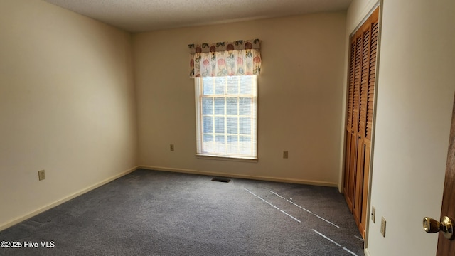 unfurnished room with baseboards, visible vents, and carpet flooring