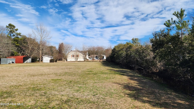 view of yard featuring a garage and an outbuilding