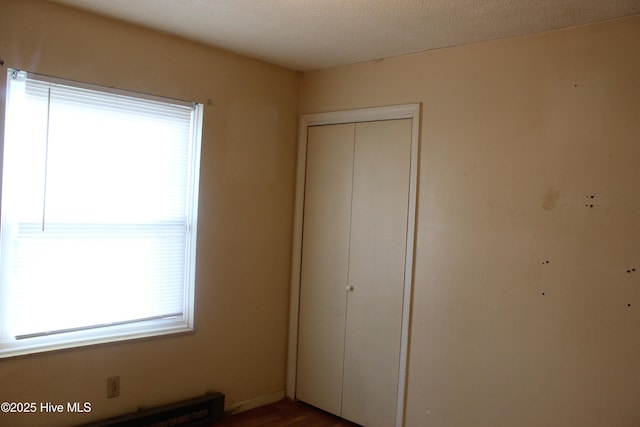 unfurnished bedroom featuring a textured ceiling and a closet