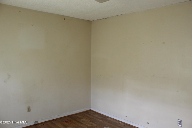 empty room with baseboards and wood finished floors