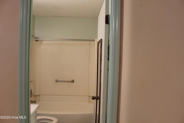 bathroom featuring shower / washtub combination and toilet