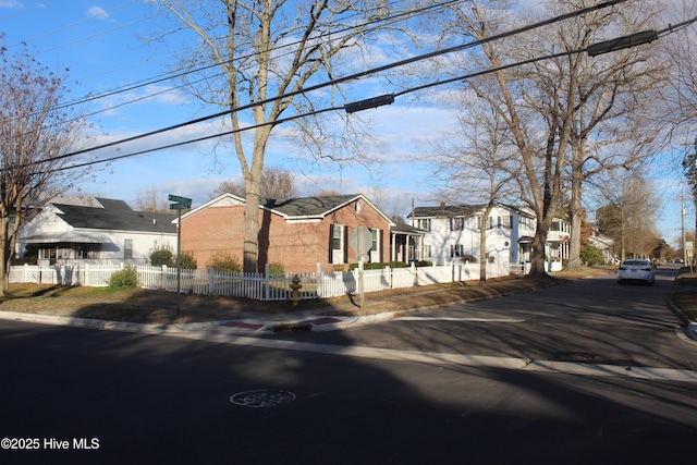 view of front of property with a fenced front yard, a residential view, and brick siding