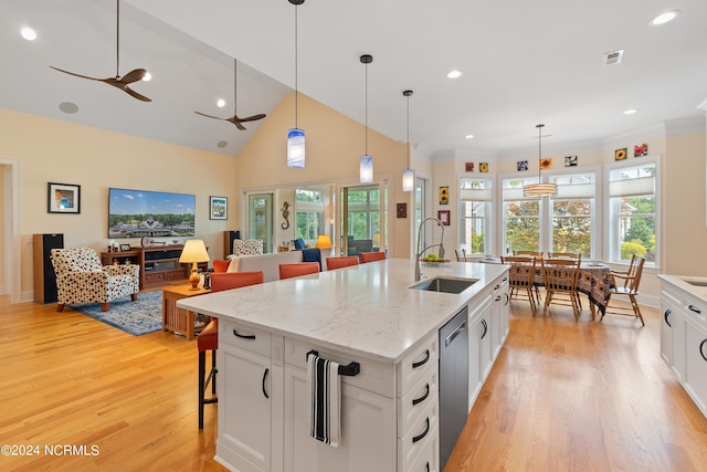 3982 Wyndmere Dr, Southport, NC 28461 - kitchen featuring a sink, a breakfast bar area, light wood-style flooring, stainless steel dishwasher, and white cabinets
