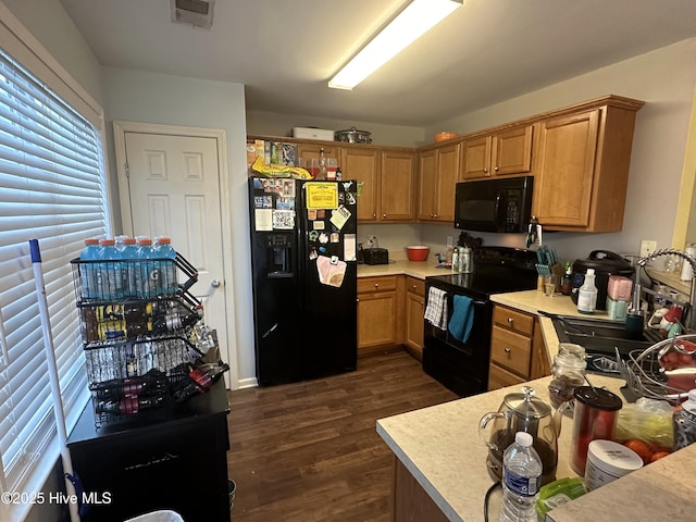 kitchen featuring black appliances, visible vents, light countertops, and dark wood-style flooring