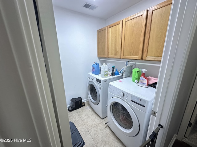 clothes washing area with cabinet space, visible vents, baseboards, washing machine and dryer, and light tile patterned flooring