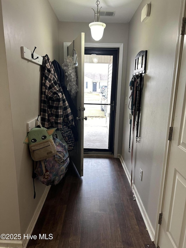 doorway featuring visible vents, baseboards, and dark wood-style flooring