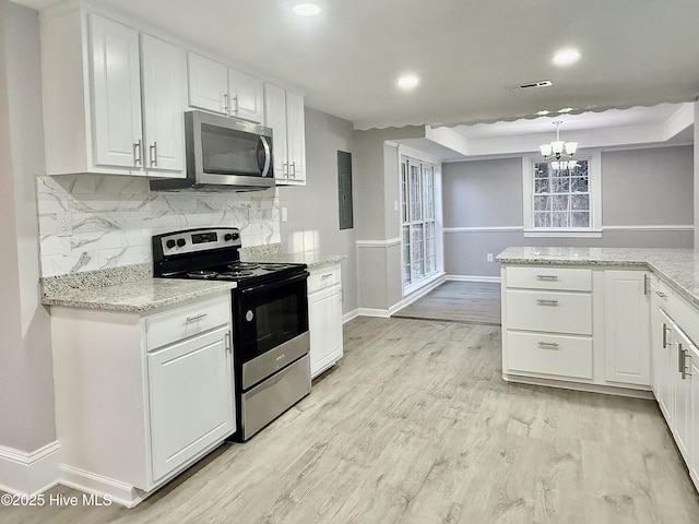 kitchen with tasteful backsplash, visible vents, light wood-style flooring, appliances with stainless steel finishes, and white cabinetry