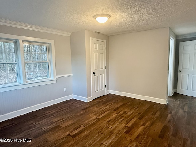 spare room with a textured ceiling, baseboards, and dark wood-style flooring