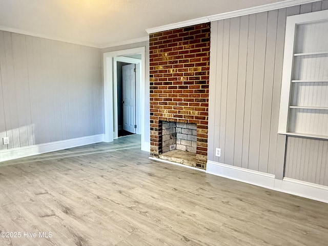 unfurnished living room with crown molding, a fireplace, built in features, and wood finished floors