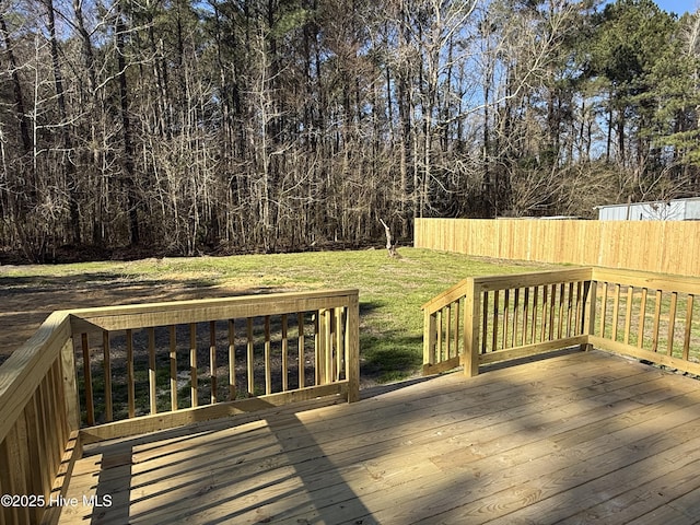 deck with a lawn and fence