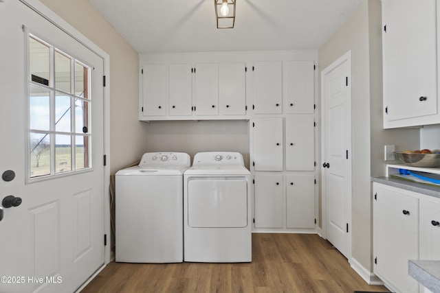 laundry room with separate washer and dryer, wood finished floors, and cabinet space