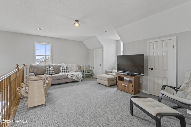 living room featuring vaulted ceiling, a textured ceiling, carpet flooring, and visible vents