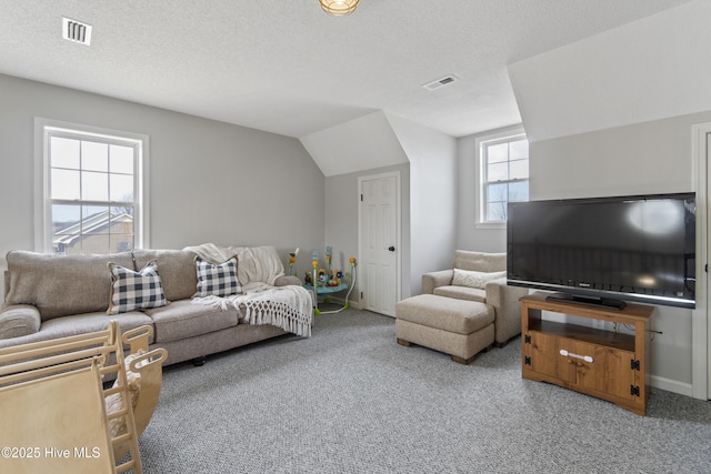 carpeted living room featuring visible vents, vaulted ceiling, a textured ceiling, and baseboards