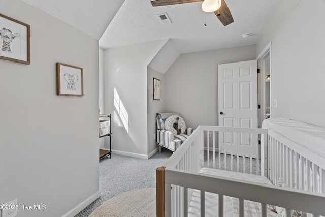 bedroom featuring carpet floors, visible vents, a textured ceiling, and baseboards