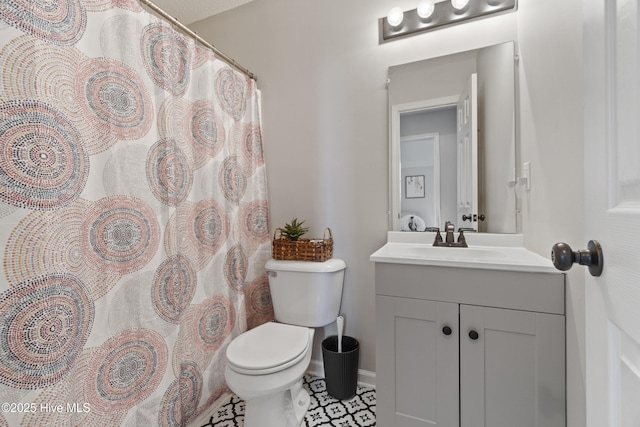 bathroom with vanity, toilet, and baseboards