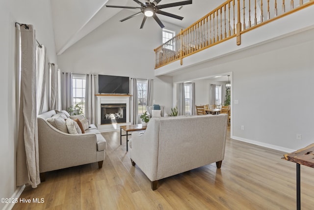 living room featuring light wood-style floors, a healthy amount of sunlight, and baseboards