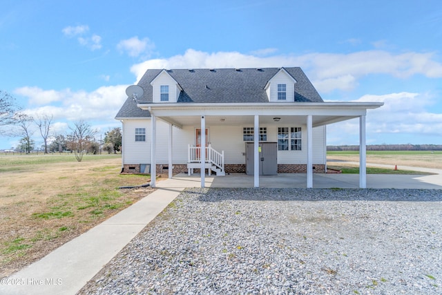 view of front of property with a shingled roof and a front lawn