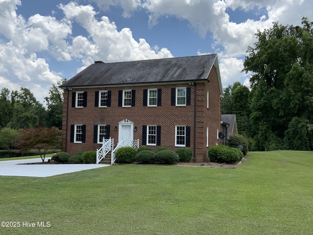 colonial-style house with brick siding and a front yard