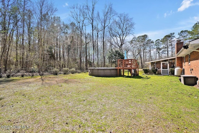 view of yard featuring an outdoor pool and a sunroom