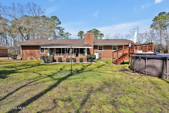 back of property with crawl space, an outdoor pool, a chimney, and brick siding