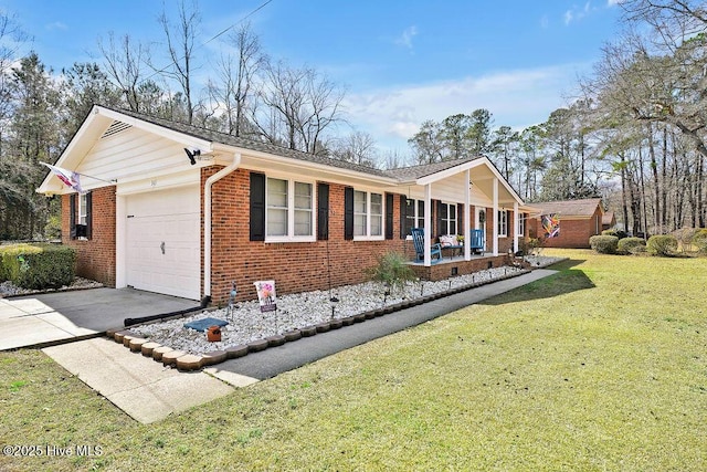 view of side of property featuring a yard, covered porch, concrete driveway, a garage, and brick siding