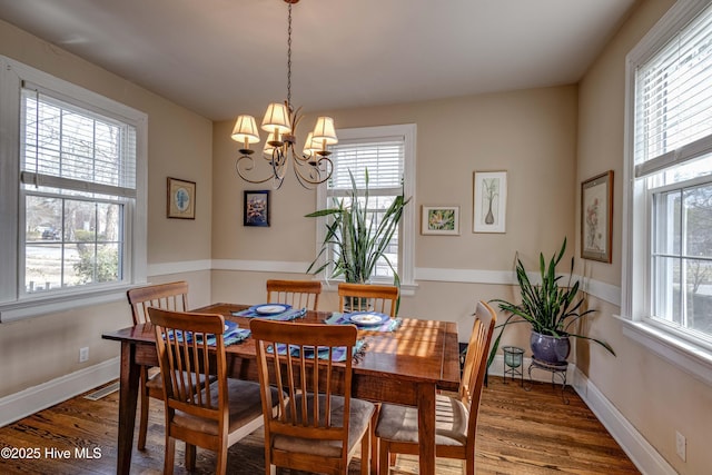 dining room featuring wood finished floors, visible vents, and baseboards