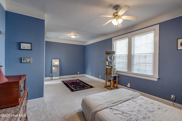 carpeted bedroom with ornamental molding, ceiling fan, and baseboards