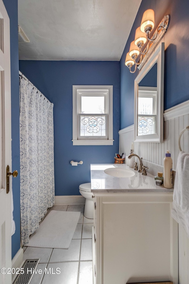 bathroom featuring tile patterned floors, plenty of natural light, visible vents, and vanity