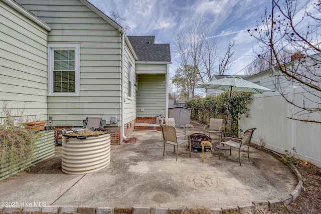 view of patio with an outdoor fire pit, an outbuilding, and a storage unit