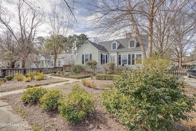 cape cod house with fence and a chimney