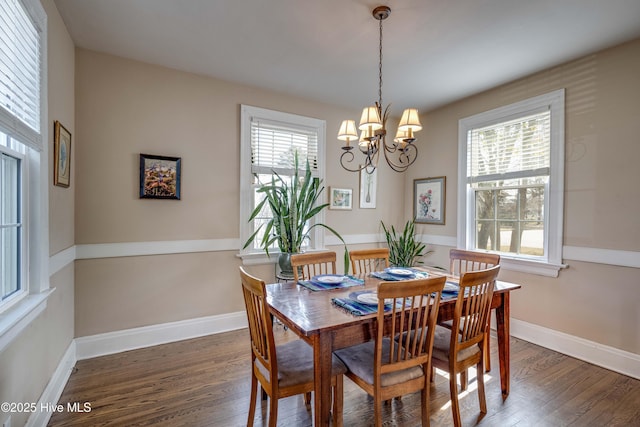 dining space with an inviting chandelier, baseboards, and wood finished floors