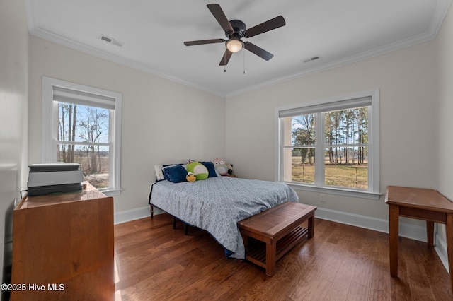 bedroom featuring ornamental molding, wood finished floors, and visible vents