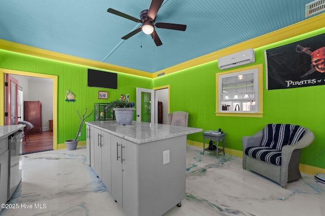 kitchen featuring ceiling fan, a kitchen island, baseboards, and a wall mounted air conditioner