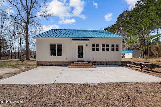 rear view of house with a patio area and metal roof