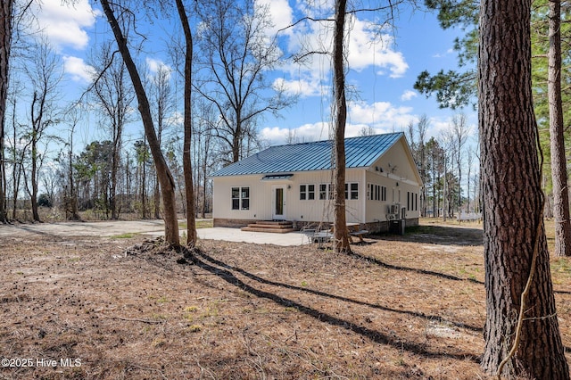 back of house with a standing seam roof and metal roof