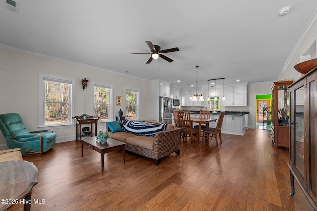 living area with ornamental molding, wood finished floors, and visible vents