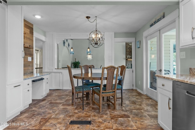 dining space featuring visible vents, a notable chandelier, a healthy amount of sunlight, and stone finish flooring