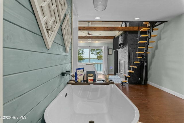 interior space featuring recessed lighting, wood finished floors, baseboards, and a sink