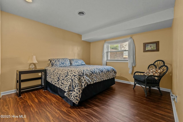 bedroom featuring visible vents, baseboards, and dark wood-style flooring