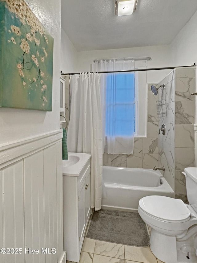 full bathroom with toilet, shower / tub combo with curtain, vanity, marble finish floor, and a textured ceiling