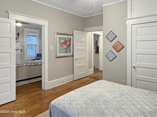 bedroom featuring a textured ceiling, wood finished floors, a closet, crown molding, and baseboards