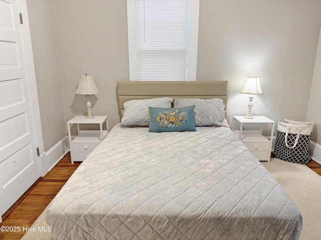 bedroom featuring baseboards and wood finished floors